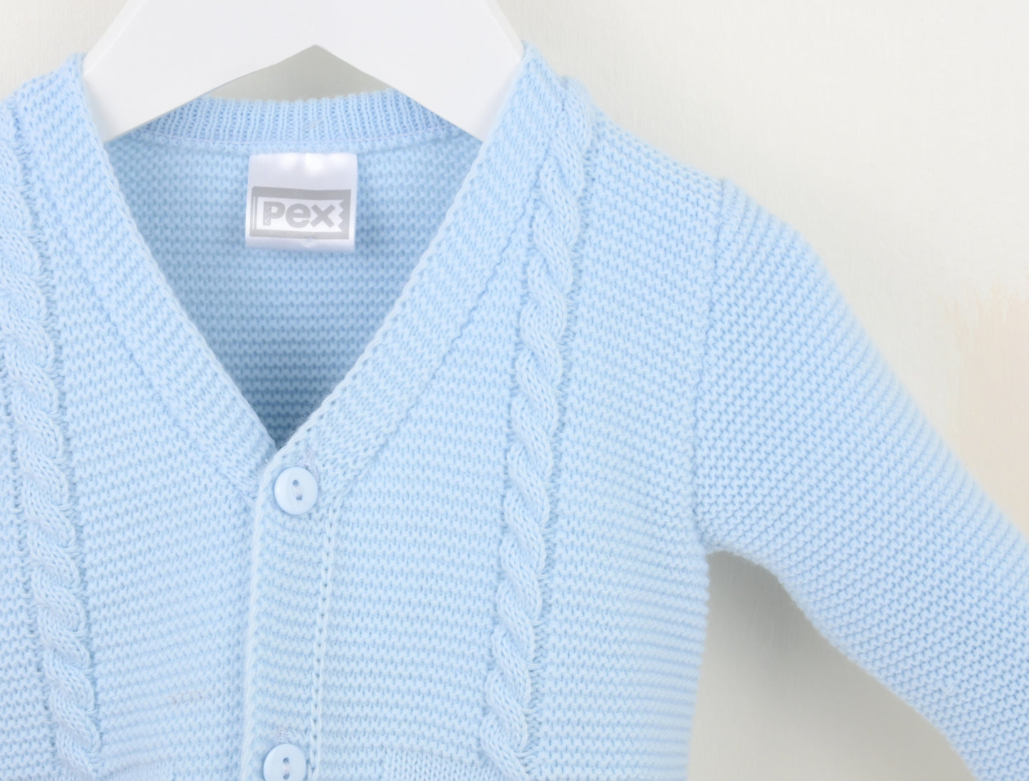 Light blue cardigan close-up: V-neck buttons and cable knit placket