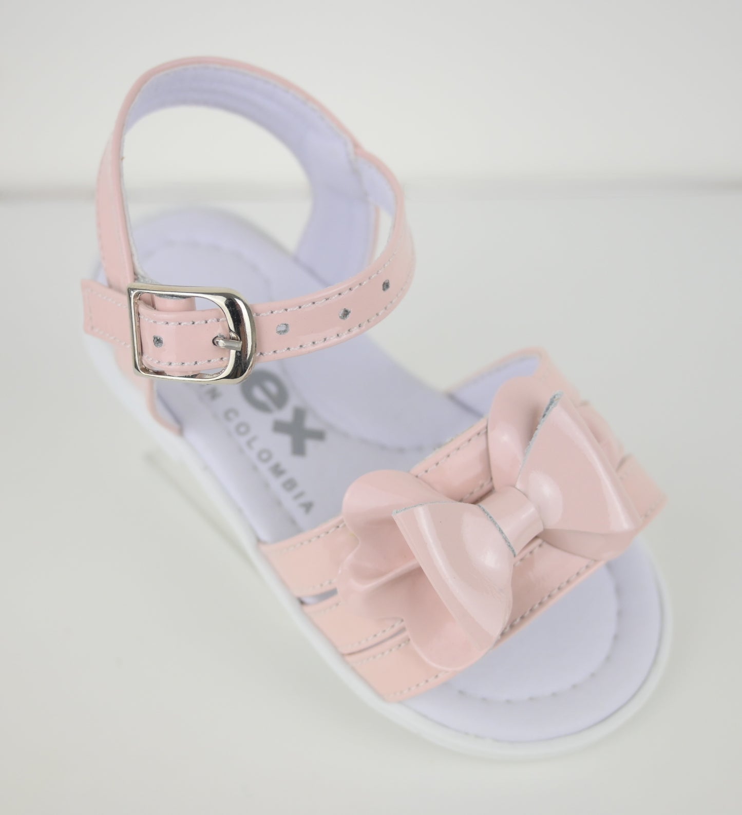 Pink toddler girls sandal with a bow on a light gray background