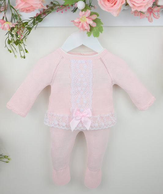 Pink baby romper with lace details on a white background with floral decorations.