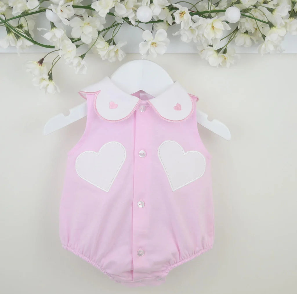 Pink girls romper front view on hanger, heart appliques and button placket