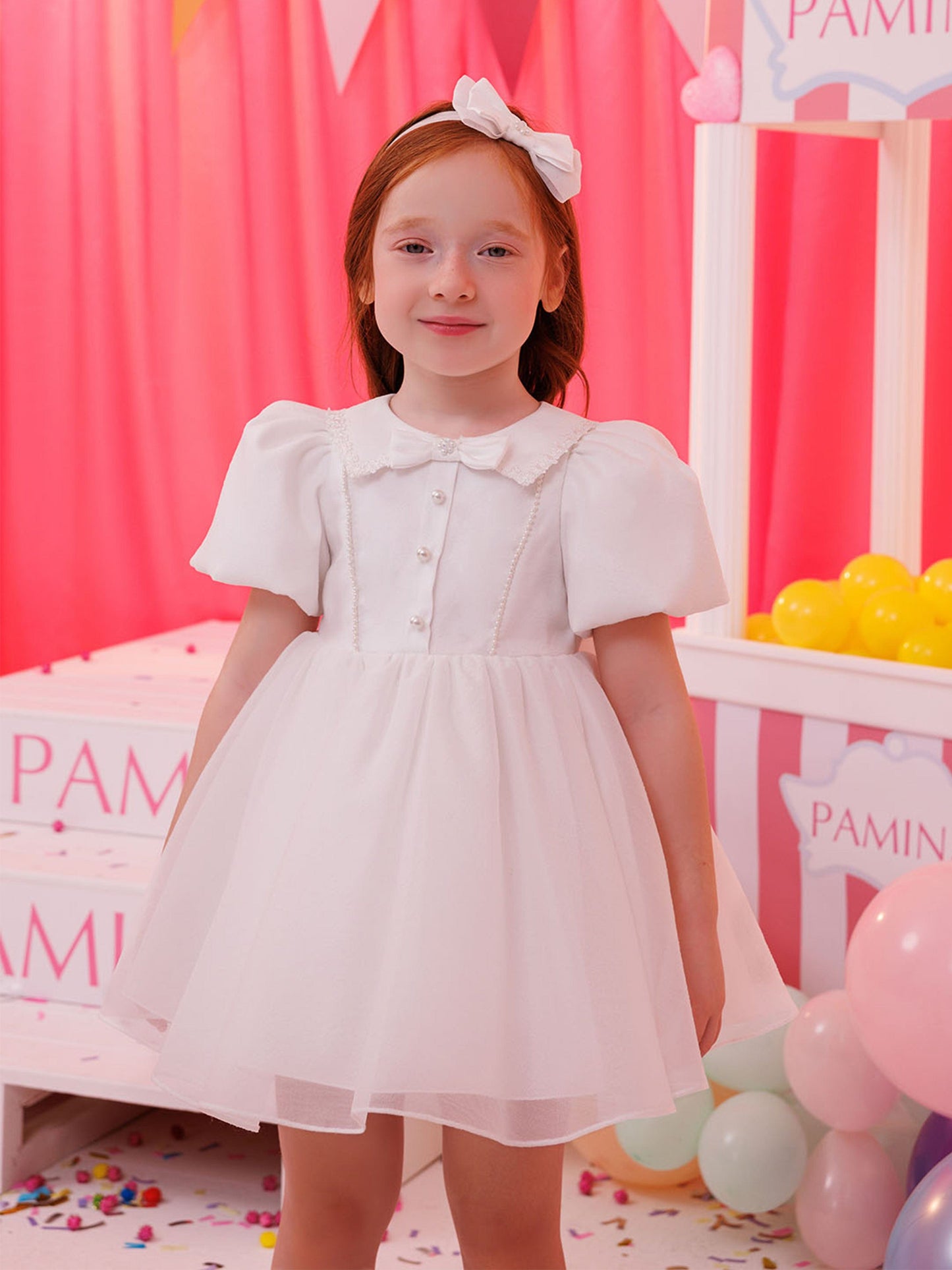 White baby dress with short puff sleeves, pearl buttons and full skirt