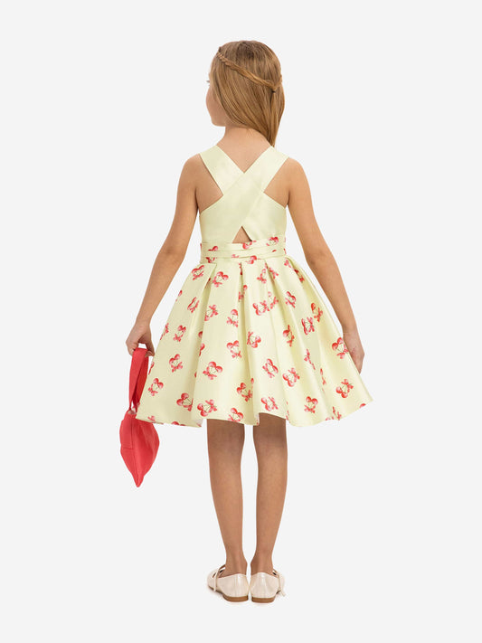 Back view: girls pale green cherry print dress with crisscross back straps and bag