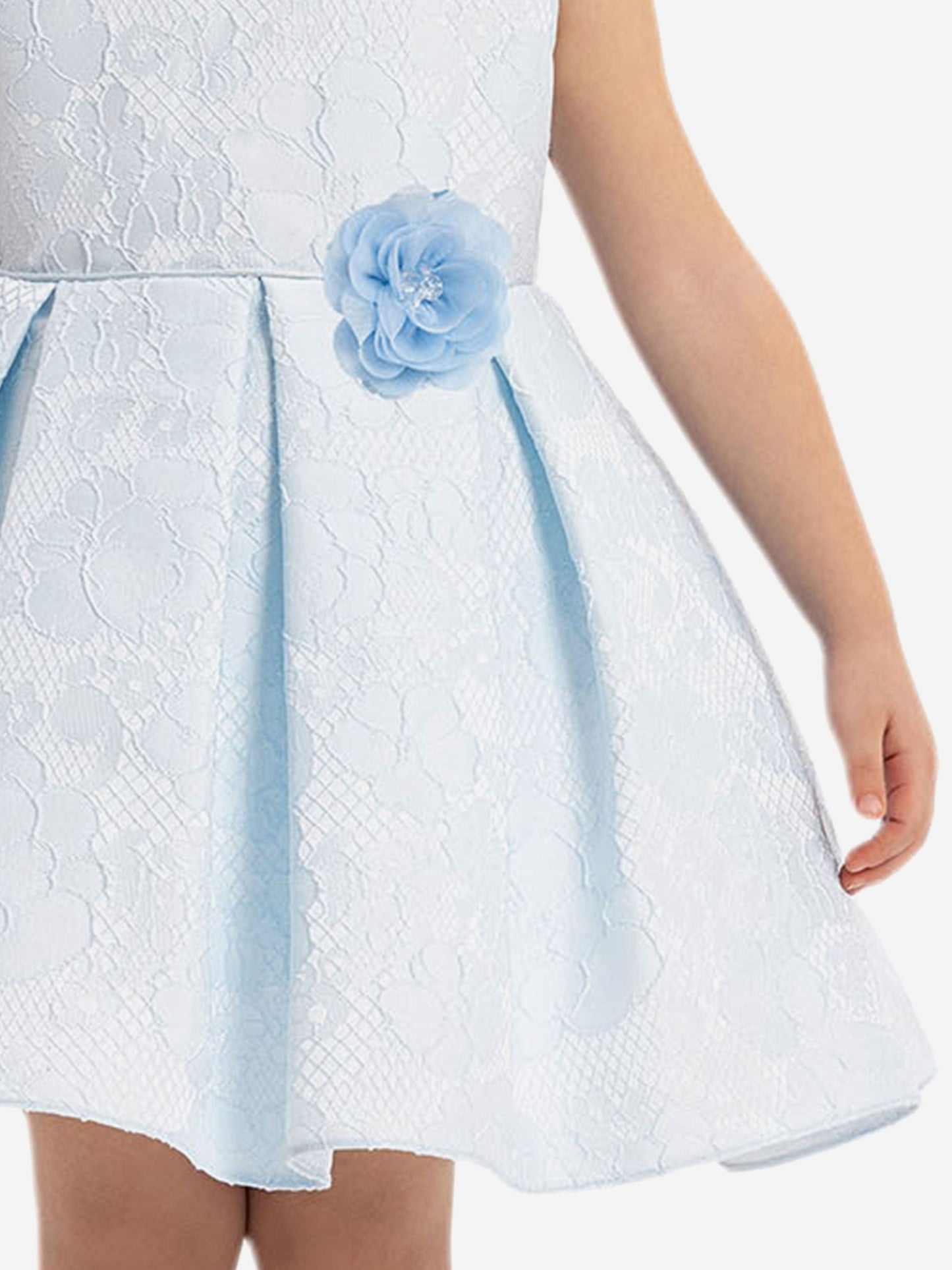 Close-up of blue rosette waist on textured white dress with light-blue trim
