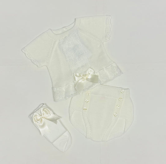White baby outfit set with a shirt, pants, and headband on a light gray background