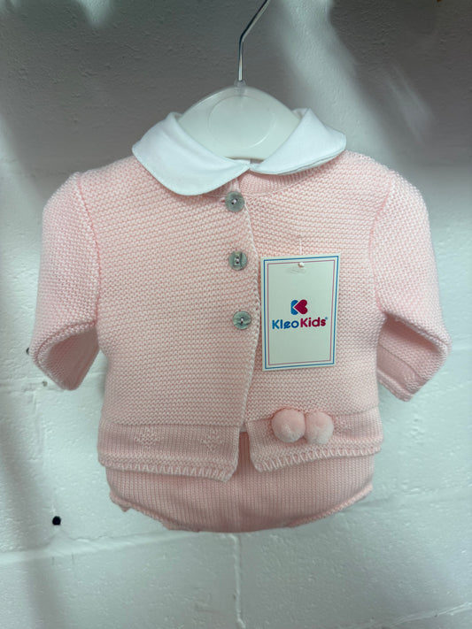 Pink knit kids jacket with white collar and pom accents, button front