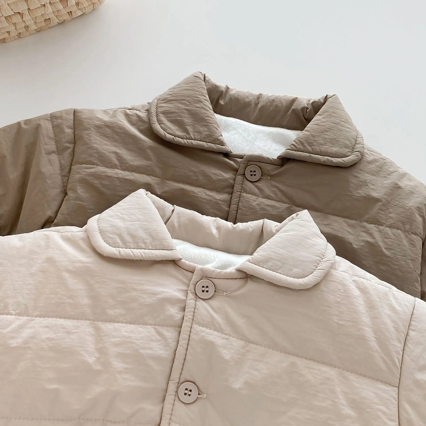 Mini puffer pocket jacket close-up, beige quilt with button placket and stitched collar