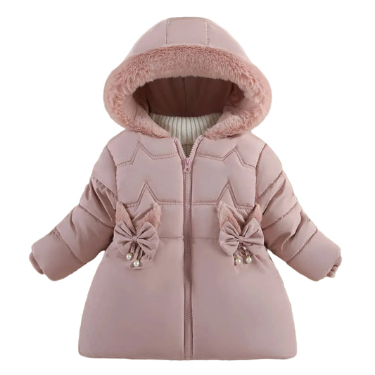 A baby girl's light pink hooded puffer jacket with a fuzzy pink hood trim, star-shaped quilting, and decorative bow details on the front pockets. The jacket is displayed flat on a beige background with decorative props including a green leaf, a yellow starfish, and a small toy camera.
