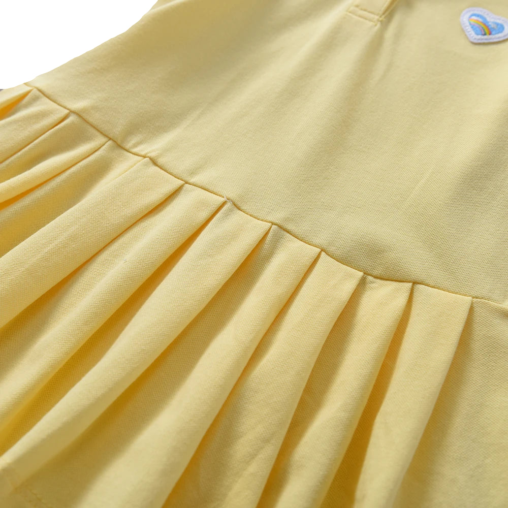 Close-up: yellow pleated skirt panel on polo tennis dress