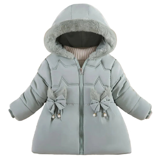 A baby girl's light blue hooded winter puffer jacket with faux fur trim, decorative bows, and pearl accents, displayed on a beige background with decorative props.
