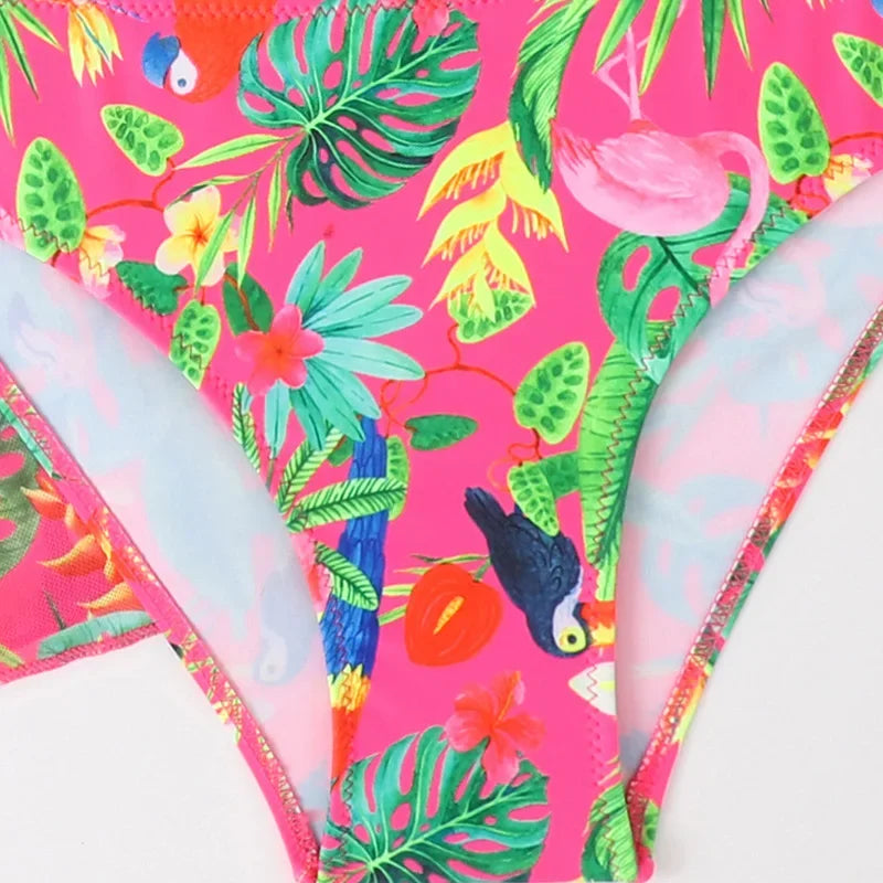 Tropical-themed bikini set with pink background and colorful foliage and animals.