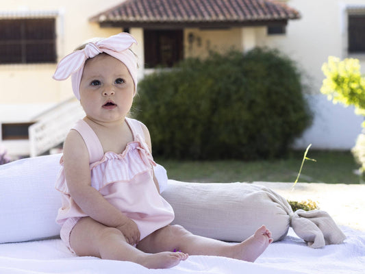Baby girl dungaree with pink-and-white striped frills and tied bow straps