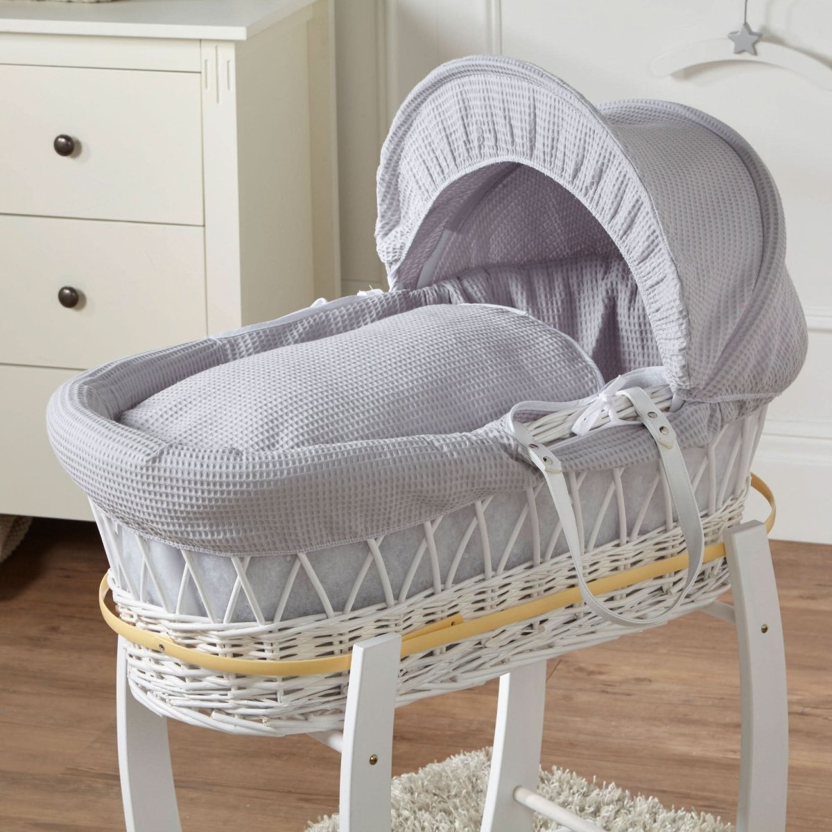Grey wicker Moses basket with white stand and light grey padded hood