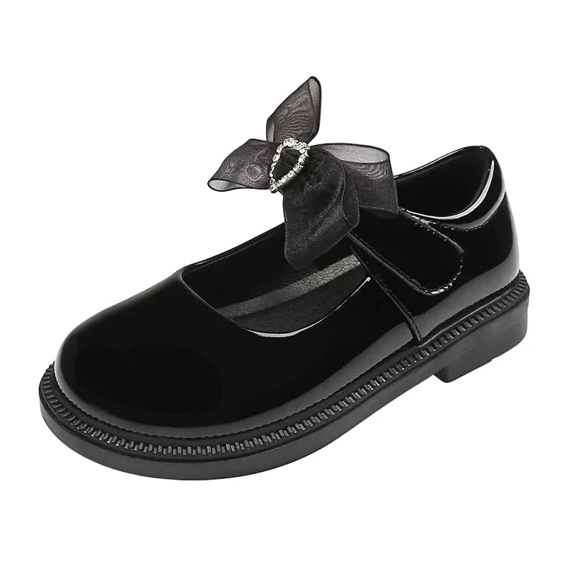 Black shoe with a decorative bow on a white background