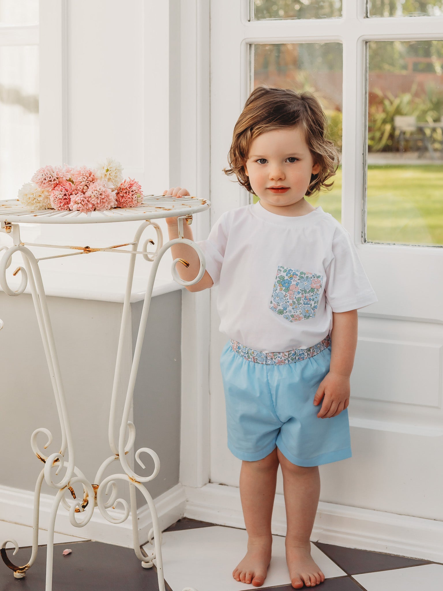 Boys white pocket T-shirt featuring a colorful floral-print chest pocket