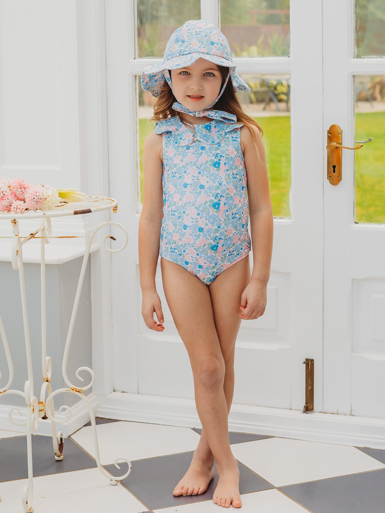 Light blue floral petal-collar sleeveless one-piece swimsuit on standing child