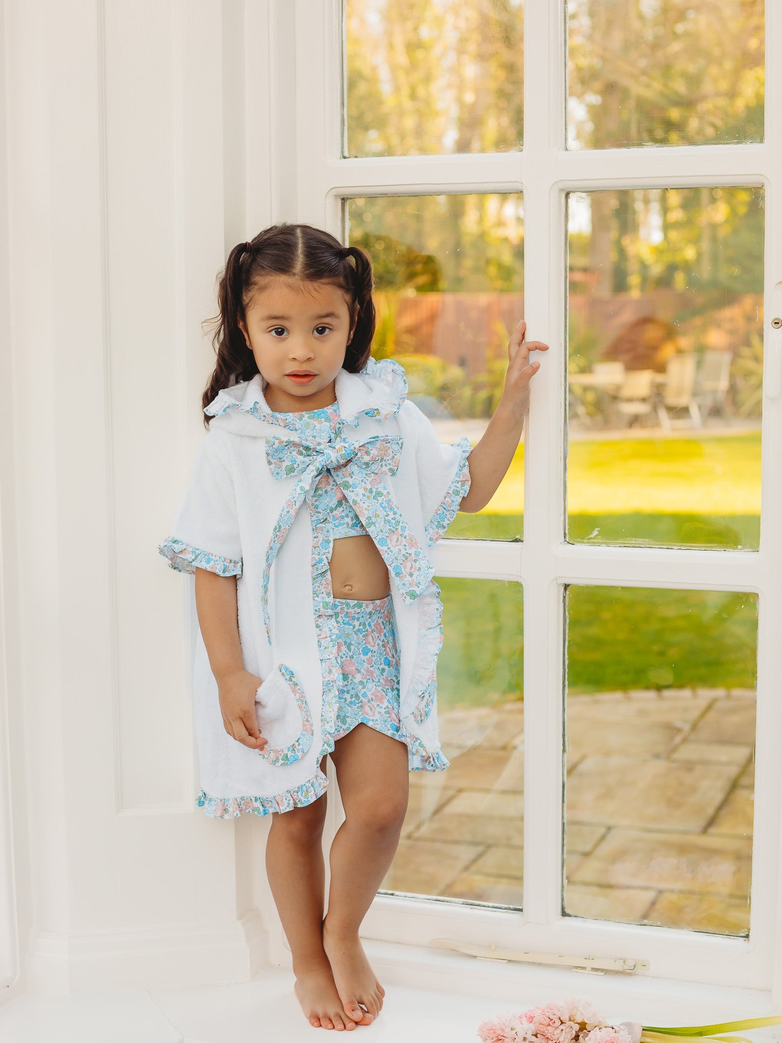 Hooded towelling poncho with blue floral bow and scalloped hem ruffle