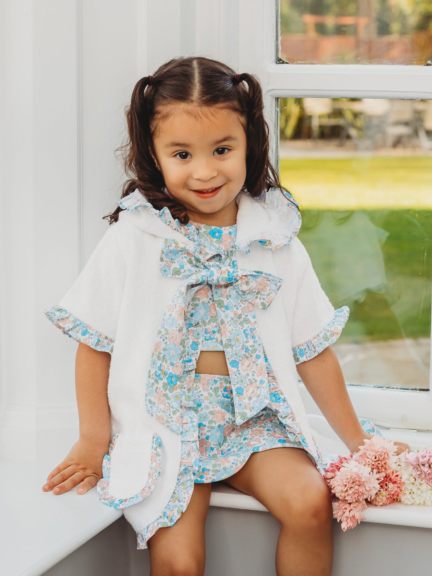 Hooded towelling poncho with blue floral hood tie and layered ruffle trim