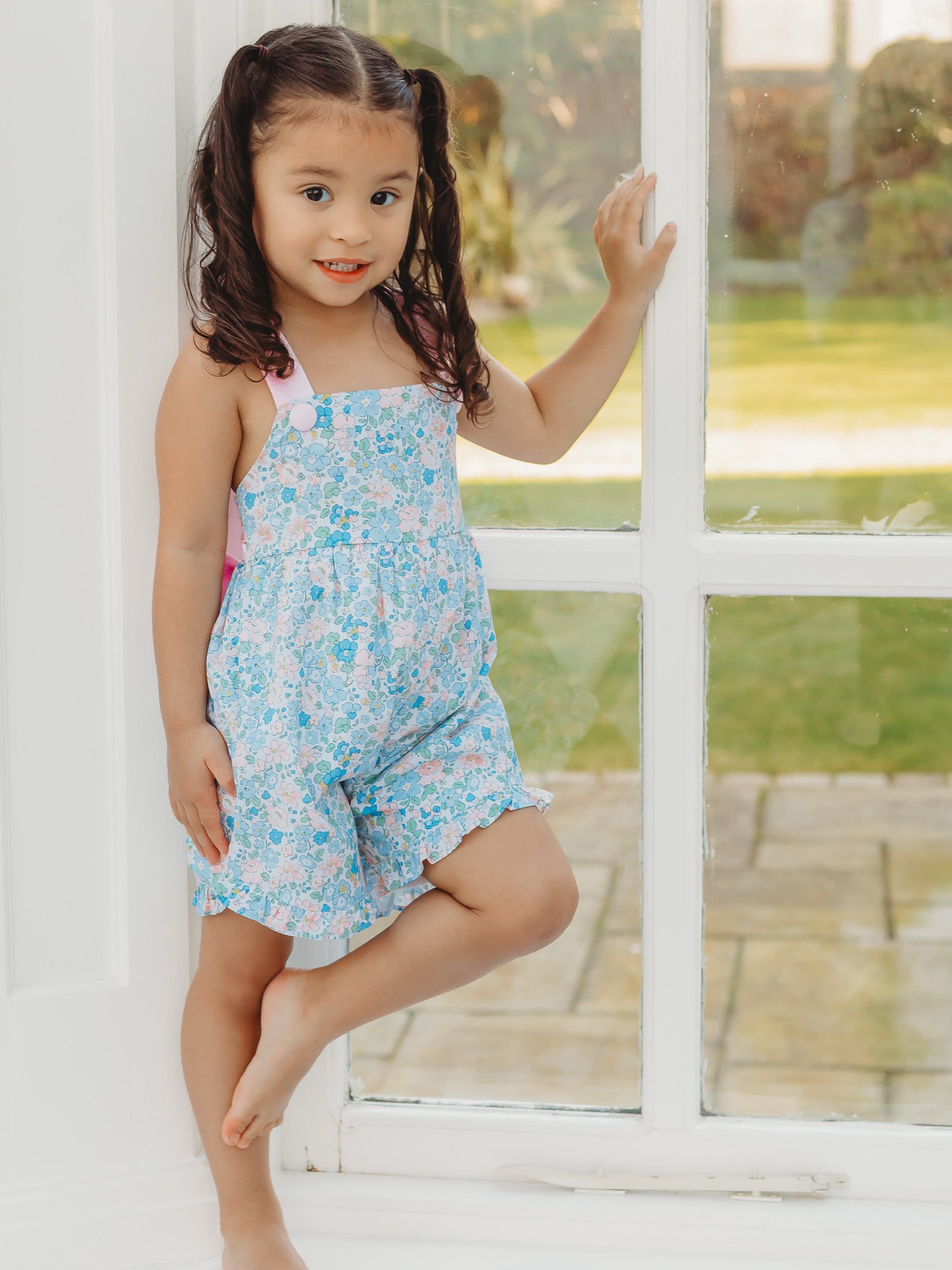 Floral playsuit with light blue print, spaghetti straps, ruffled shorts