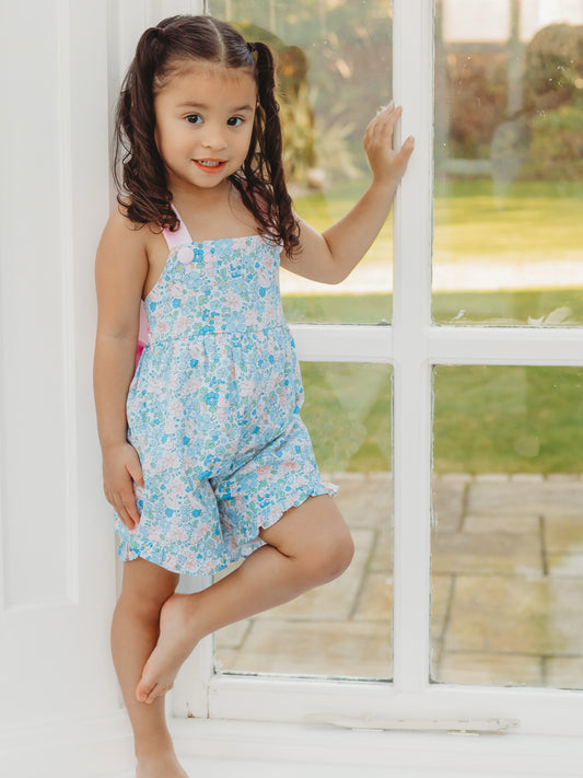 Floral playsuit with light blue print, spaghetti straps, ruffled shorts