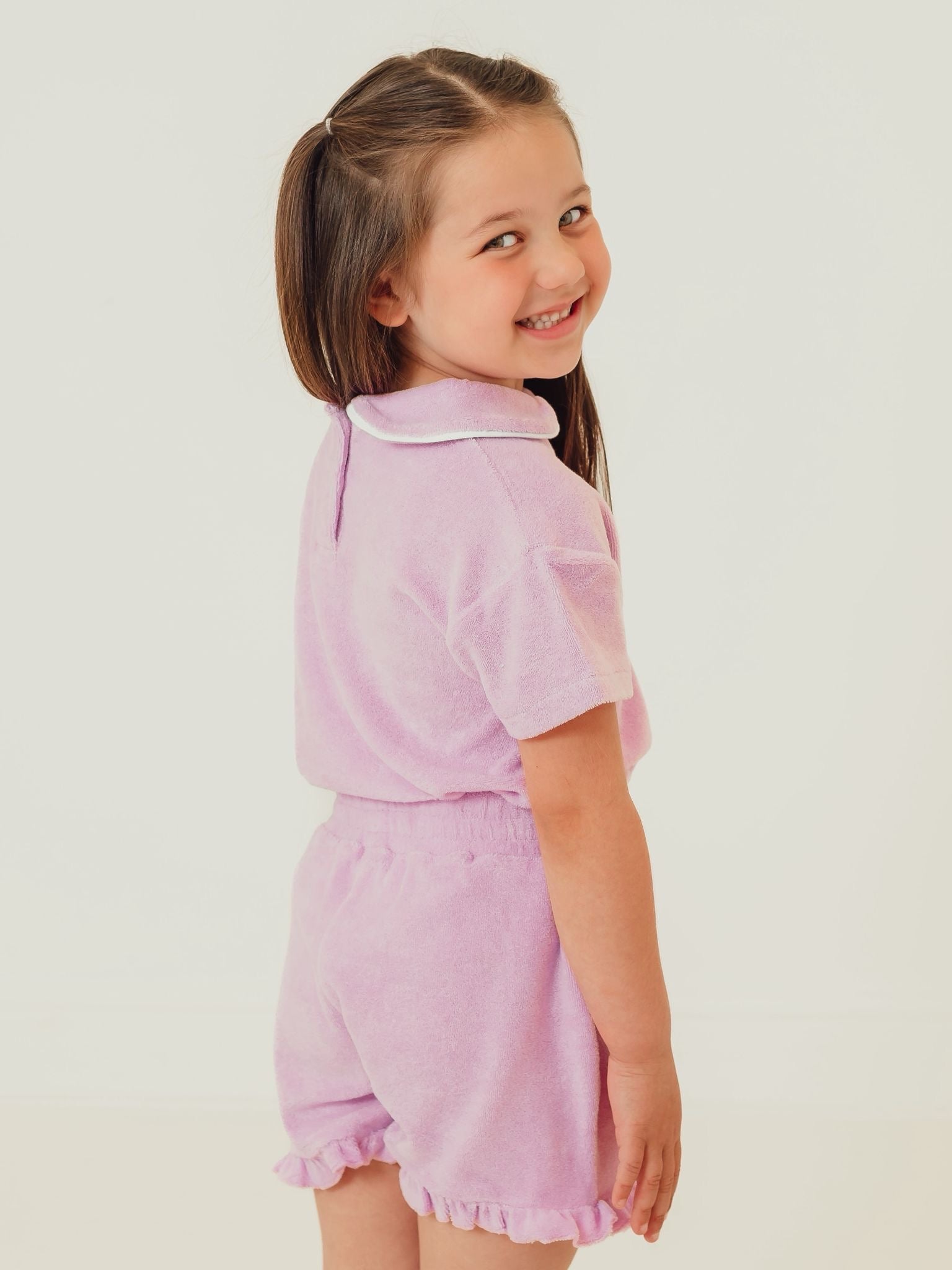 Lilac towelling short set viewed side, with ruffled collar and hem shorts