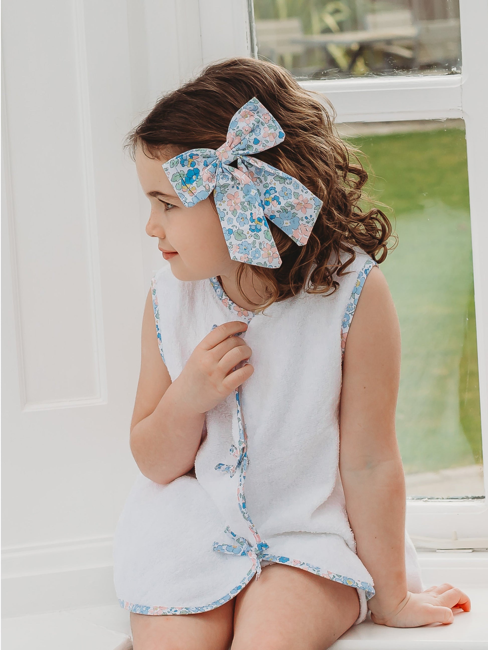 White towelling sleeveless top with blue floral bow applique and matching shorts
