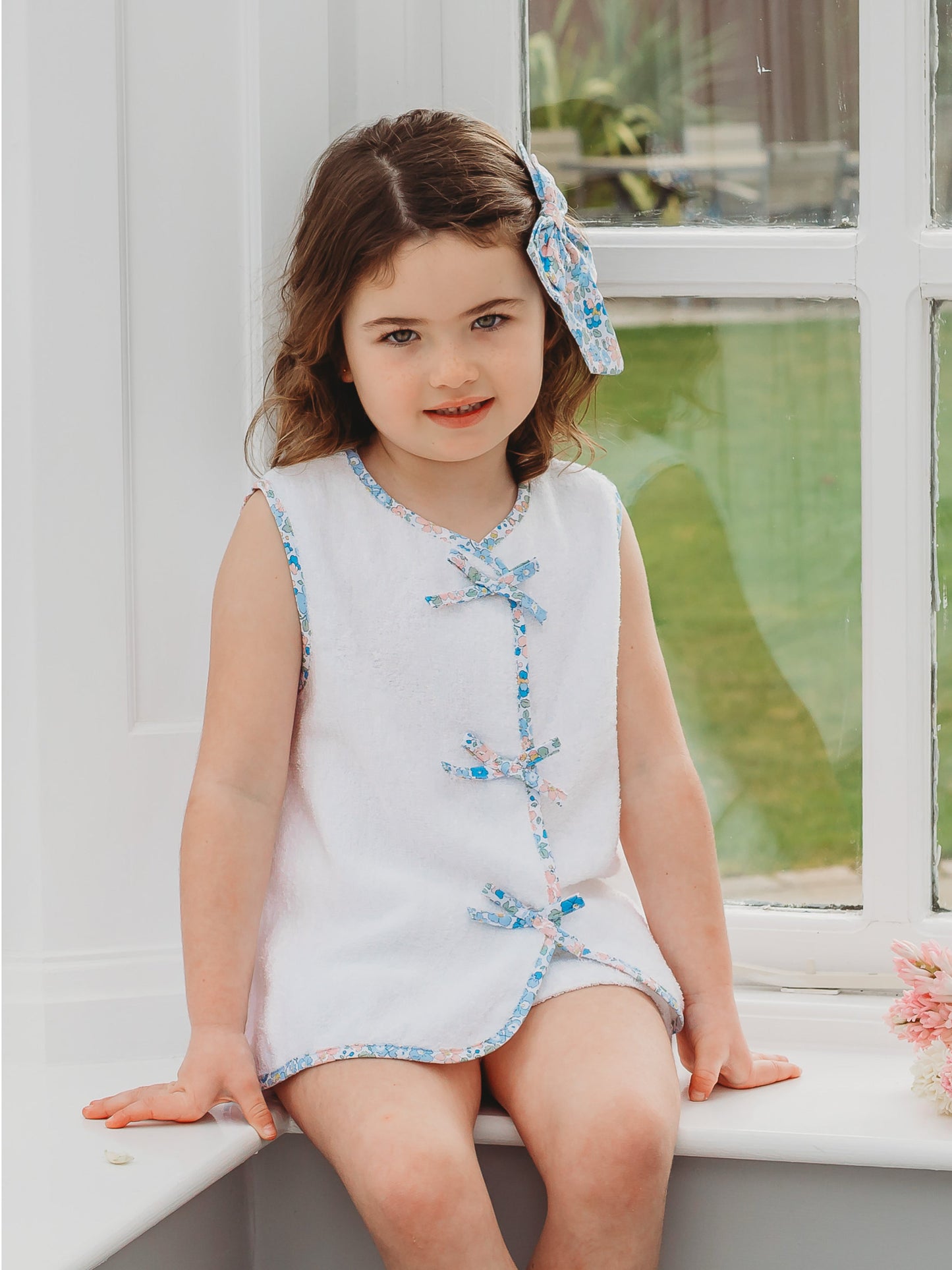 White sleeveless towelling top with blue floral cross-front trim; matching shorts