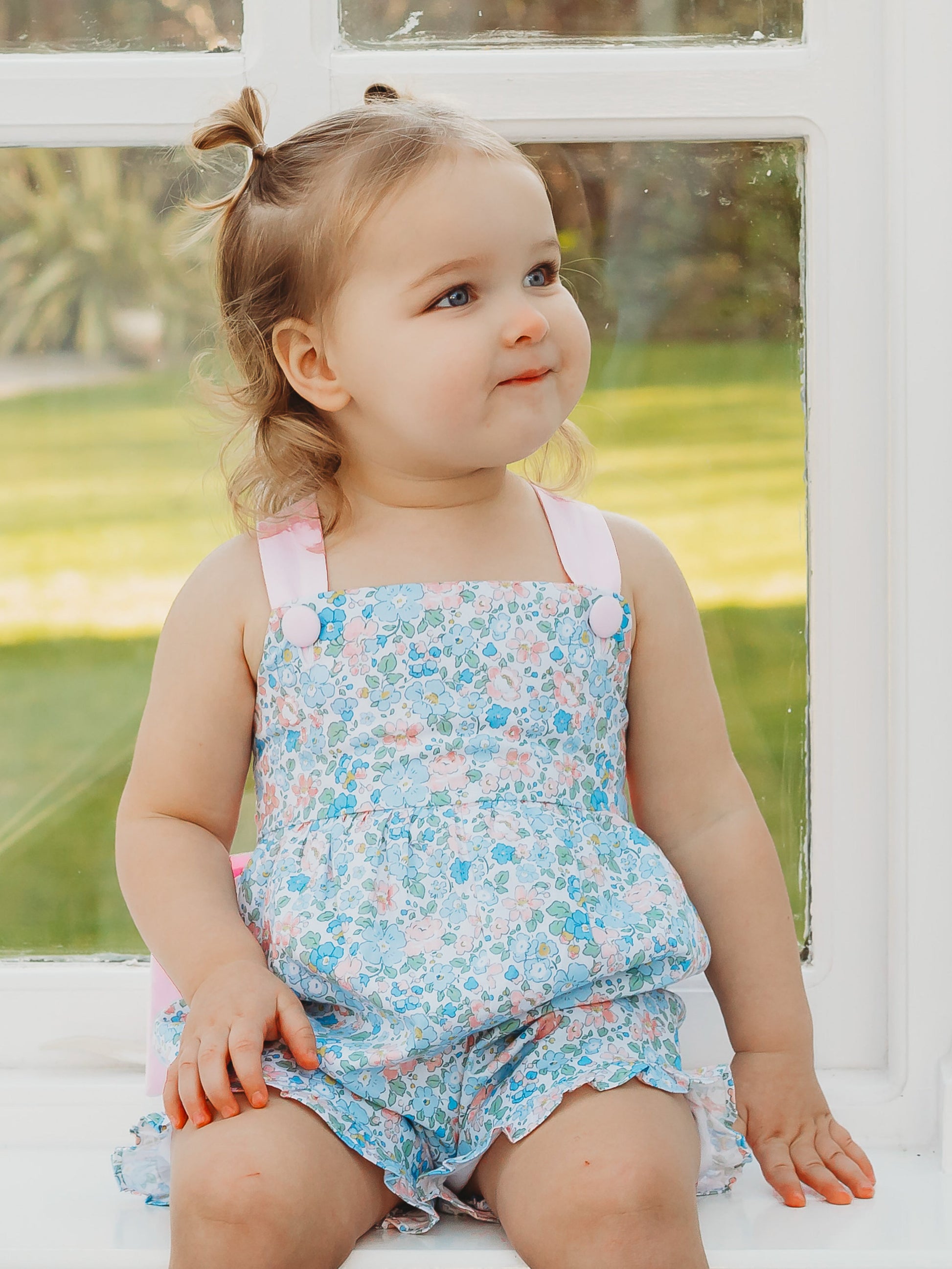 Floral playsuit with light blue print and pink trim, spaghetti straps, ruffled hem