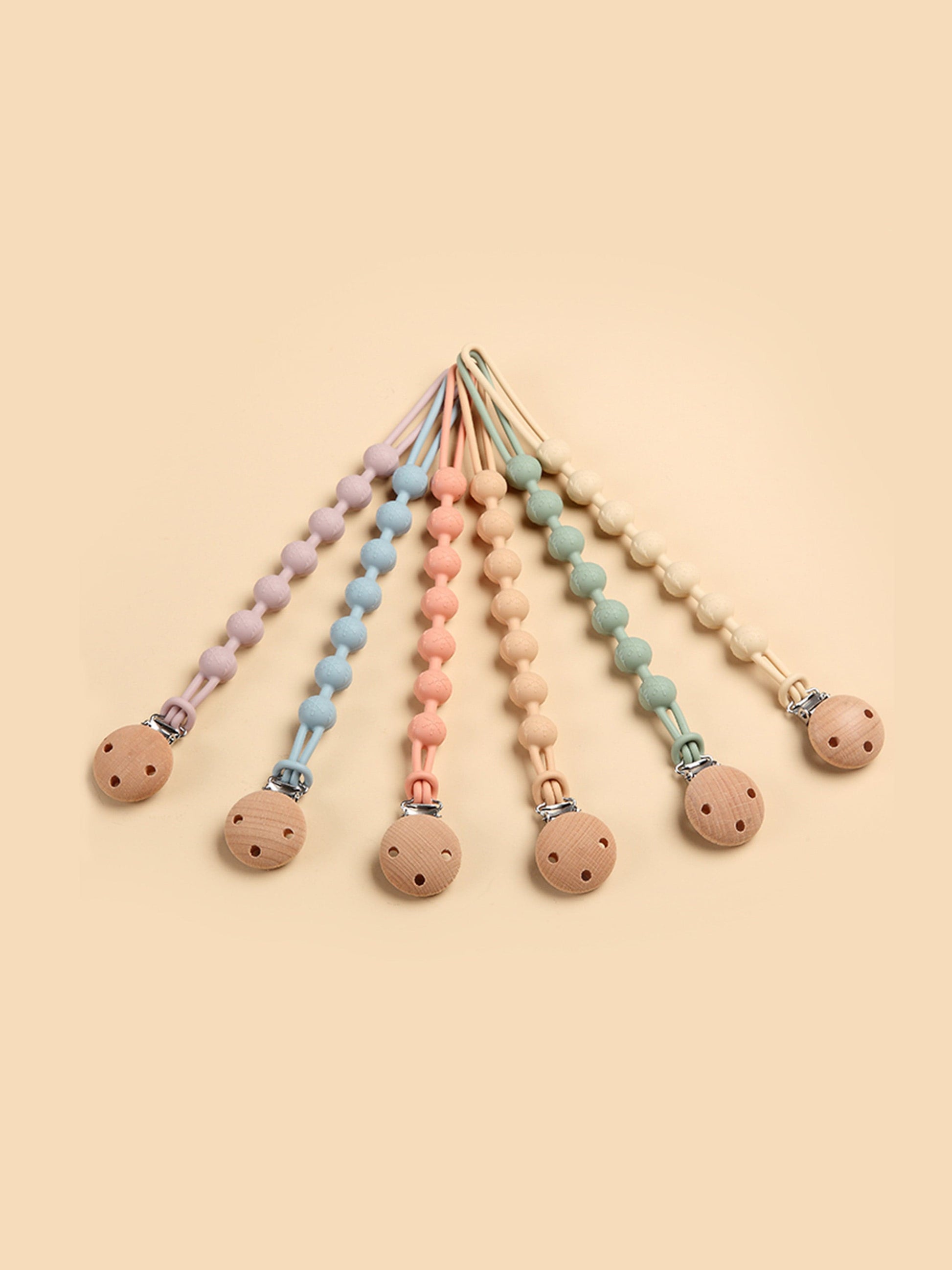 Assorted pacifier clips with silicone beads and wooden teether discs in multiple colors