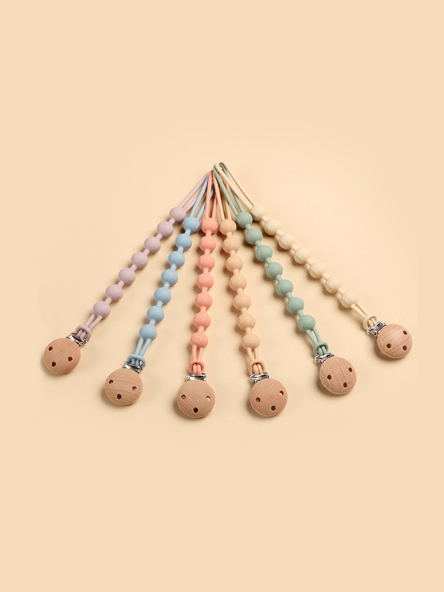 Pacifier clips and teethers in multiple pastel colors with round wooden ends