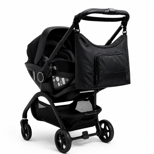 Black changing bag attached to stroller with cross straps