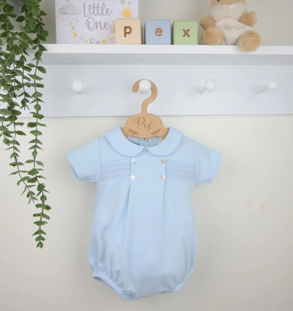 Pastel blue smocked cotton romper on hanger, short sleeves and buttoned front