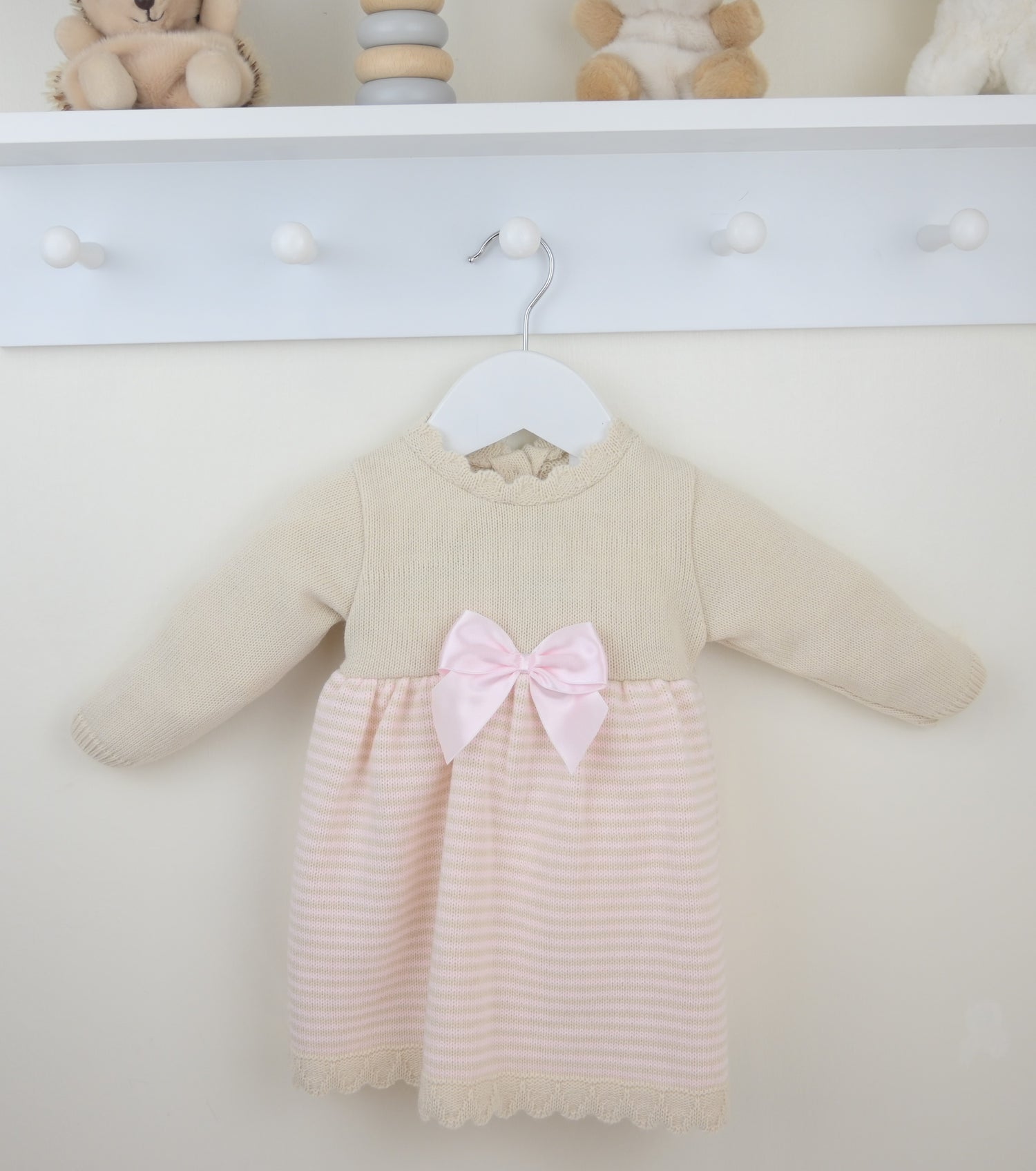 Girls pearl pink dress with cream knit long sleeves, striped skirt, and pink bow