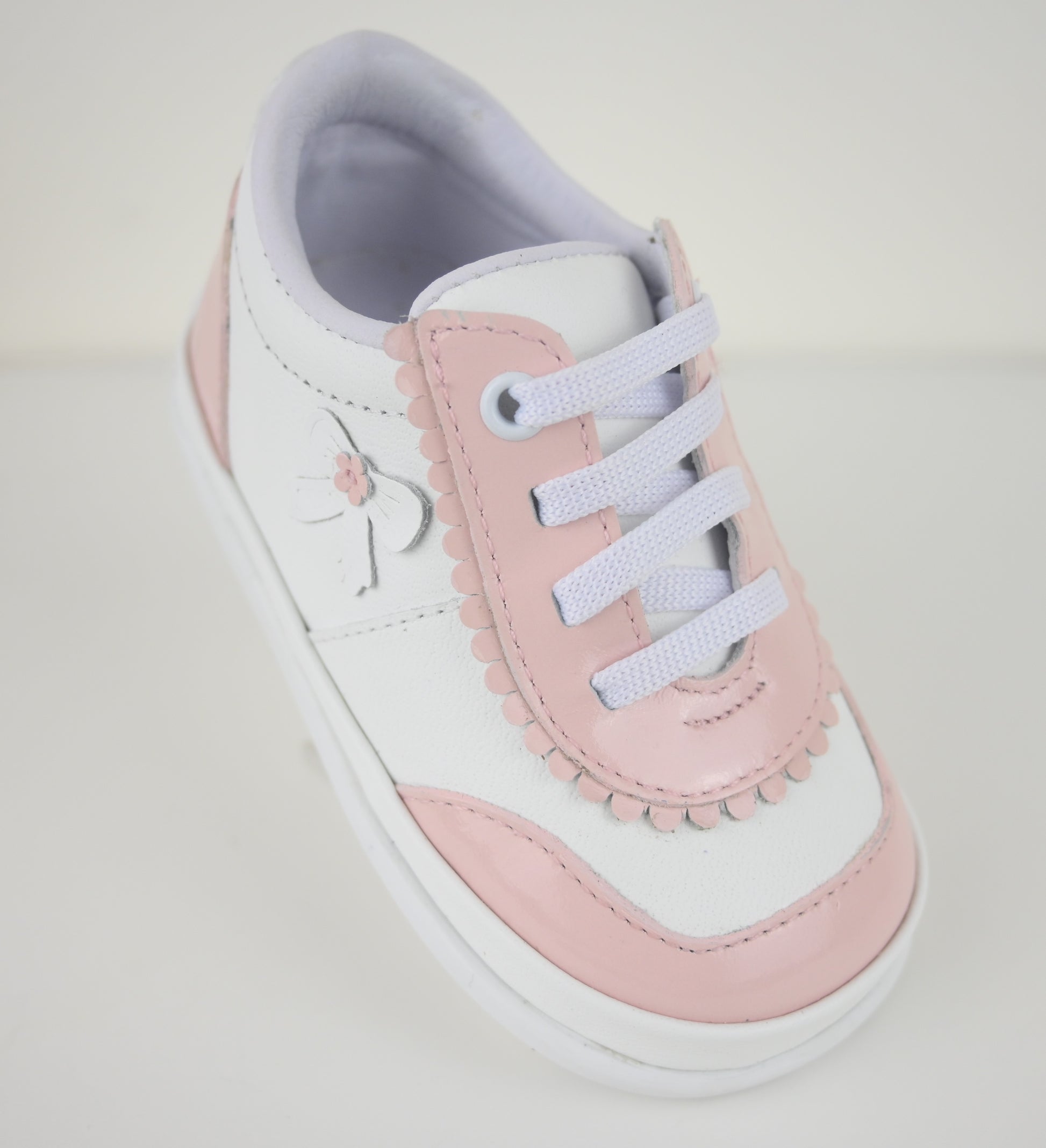 Pink and white sneaker on a light gray background
