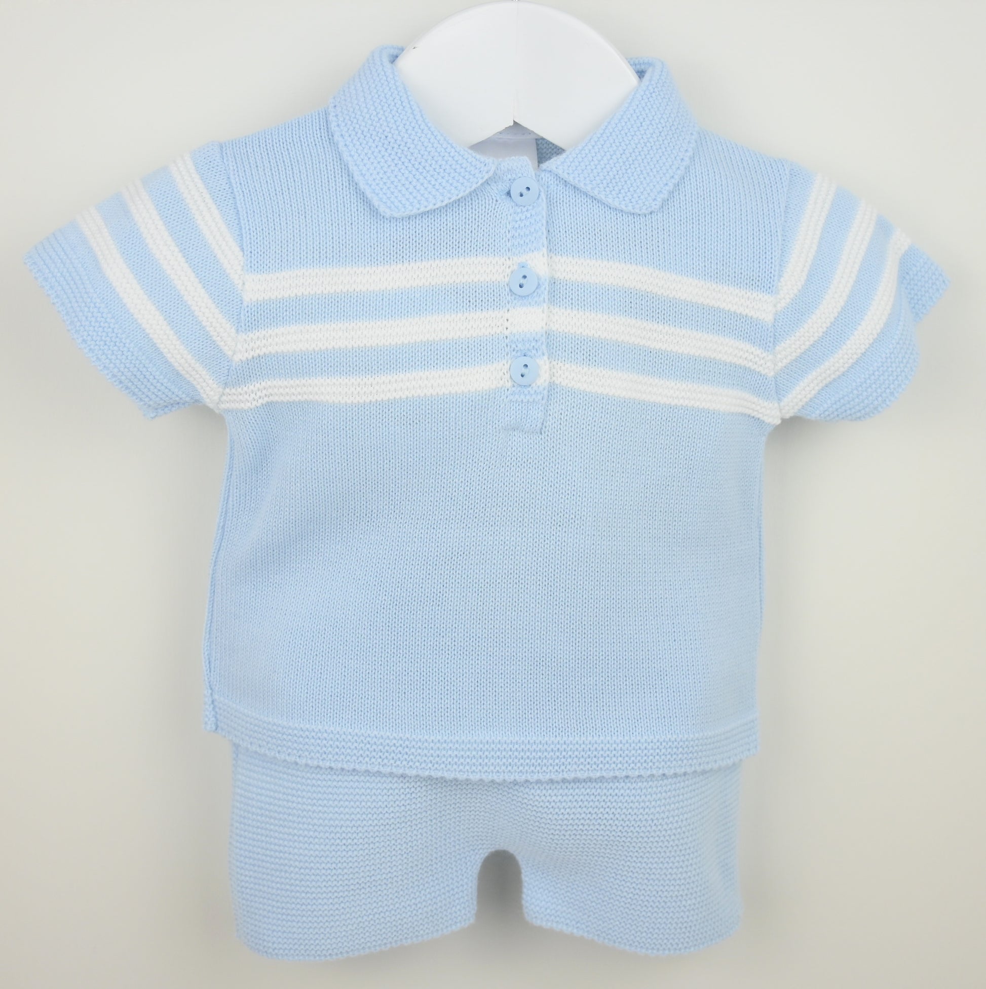Light blue baby outfit with a polo shirt and shorts on a hanger against a light gray background