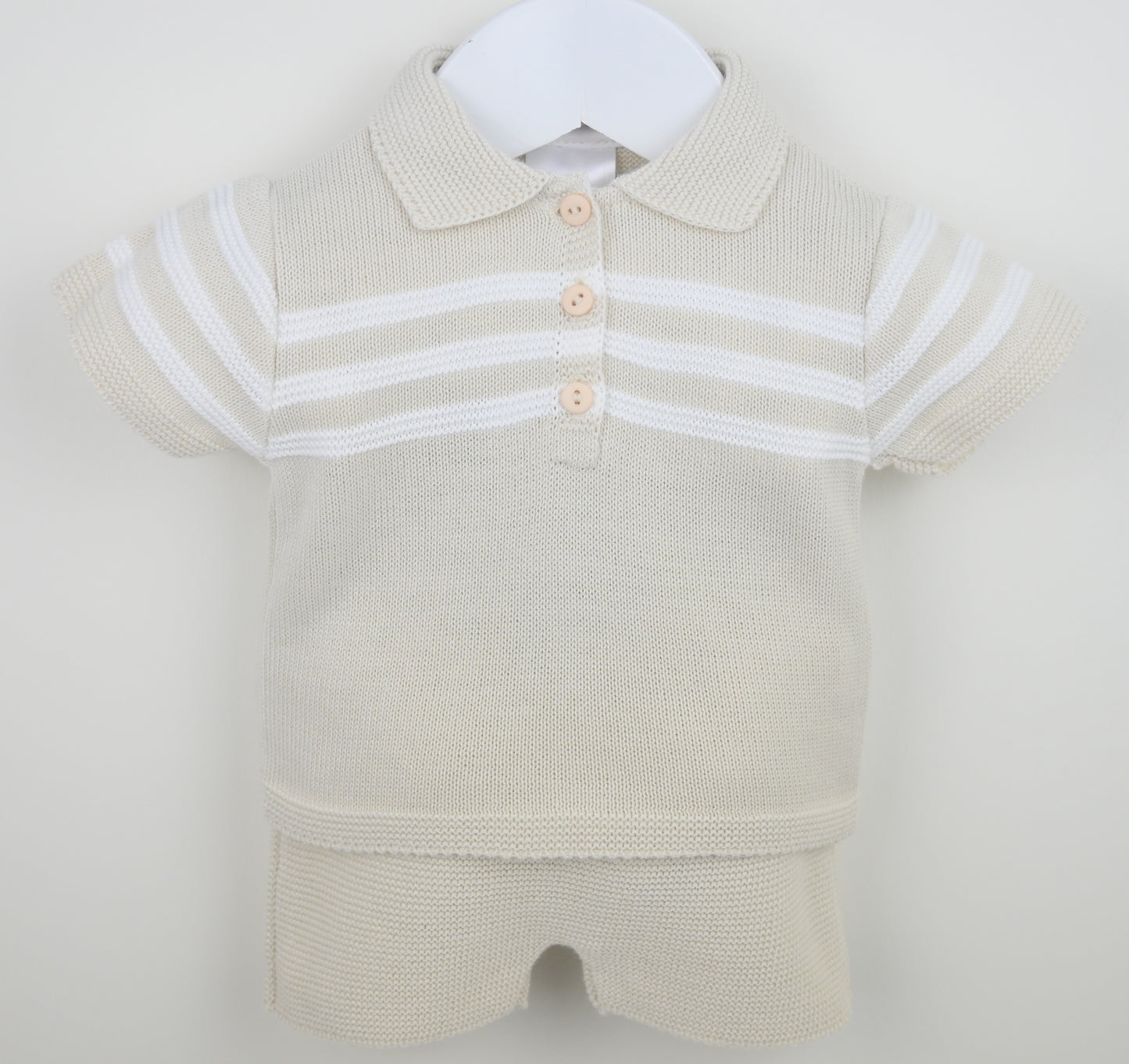 Beige baby romper with white stripes on a white background