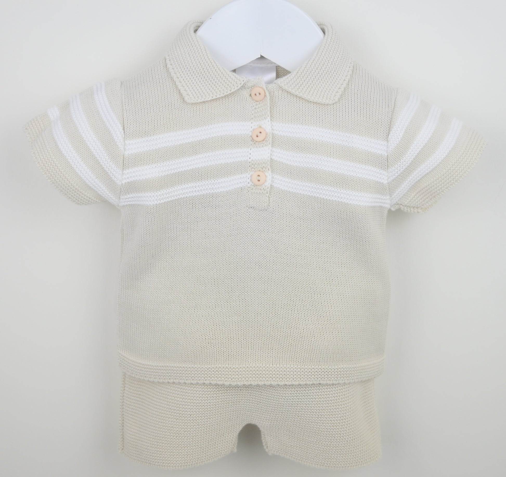 Beige baby romper with white stripes on a white background