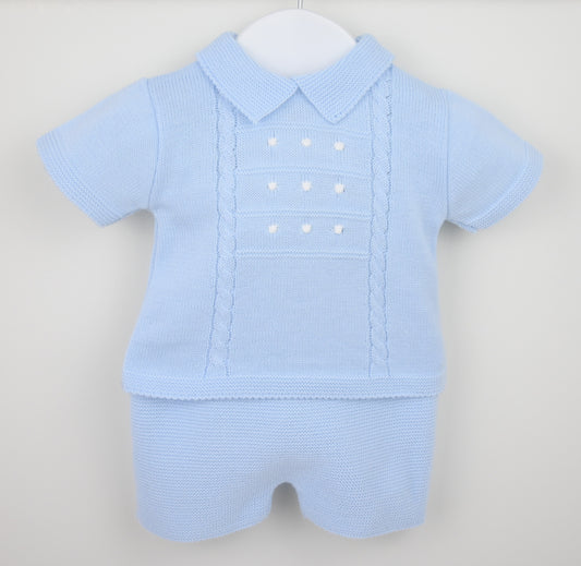 Baby blue knitted shorts suit with collar and cable detail displayed on hanger