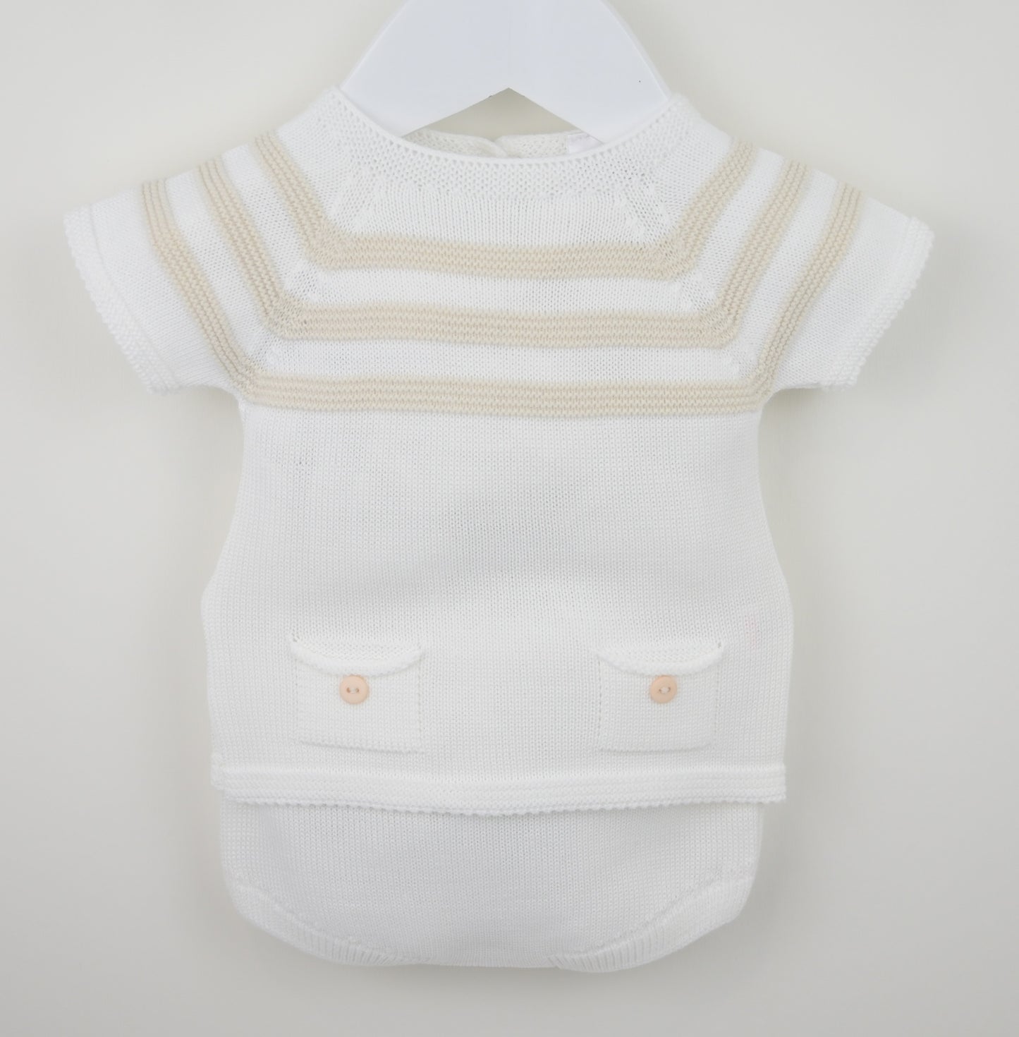 White baby romper with beige stripes on a hanger against a white background