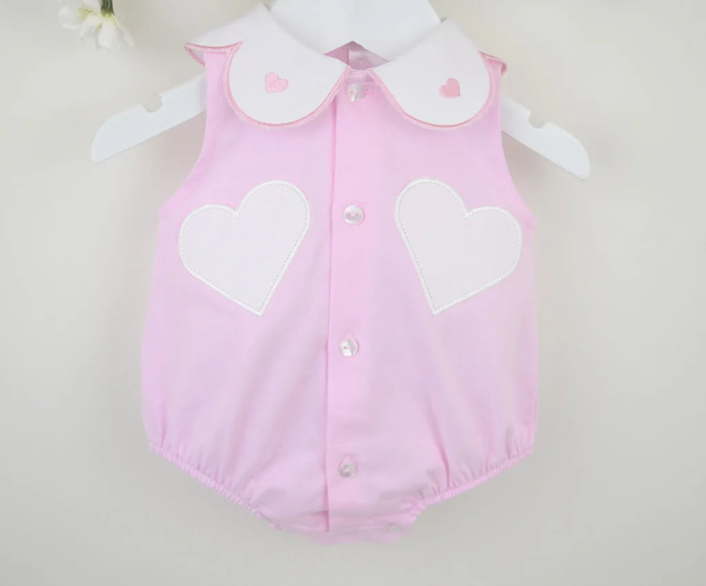 Pink girls romper flat lay: heart patch panels, Peter Pan collar, button placket