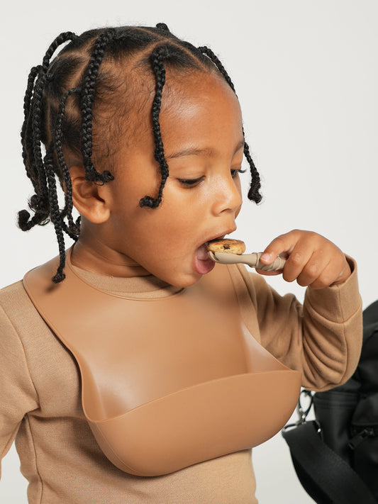Orange silicone spoon held for eating