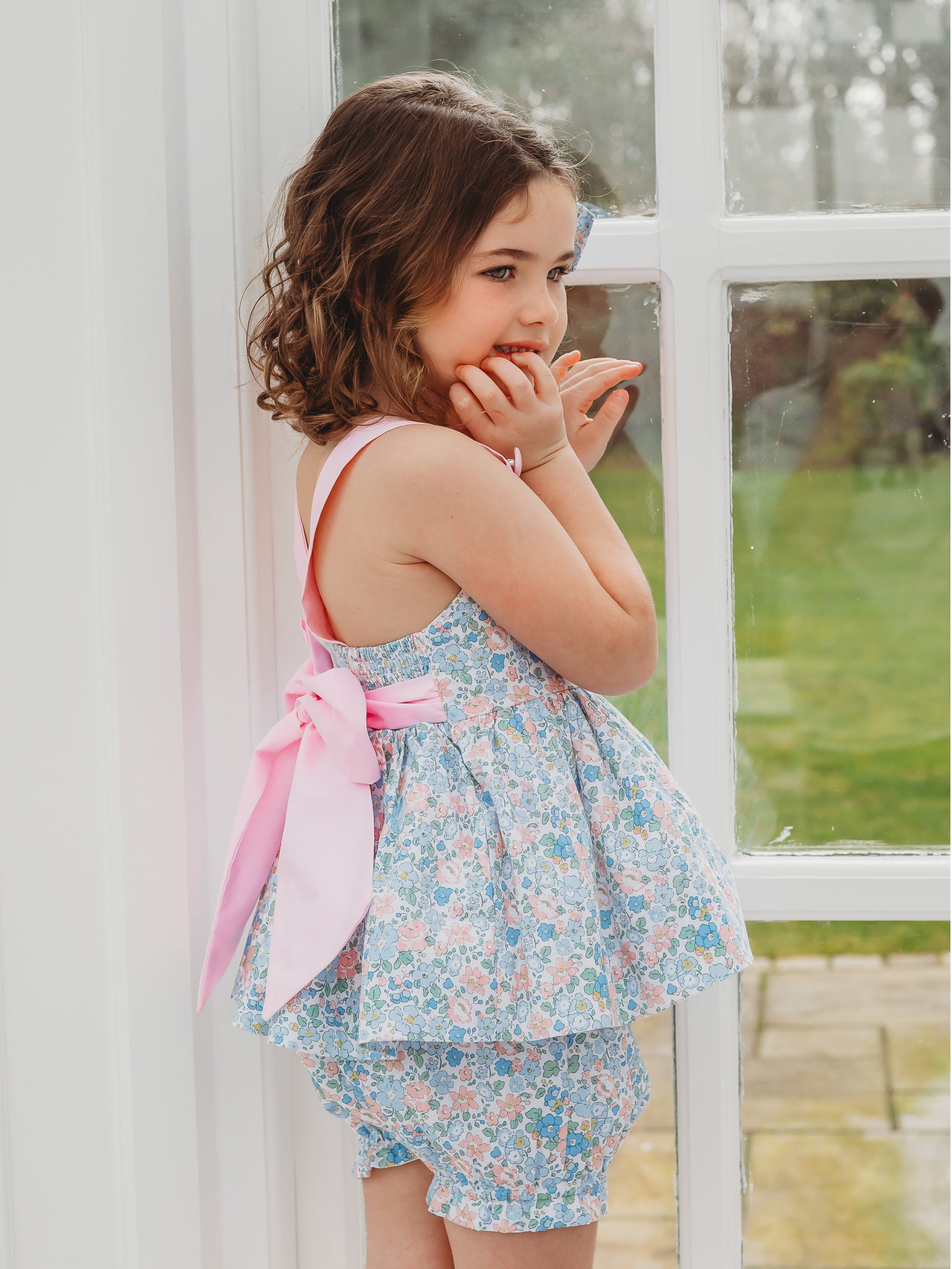 Floral bow-back bloomer set in light blue with pink waist sash and ruffle skirt