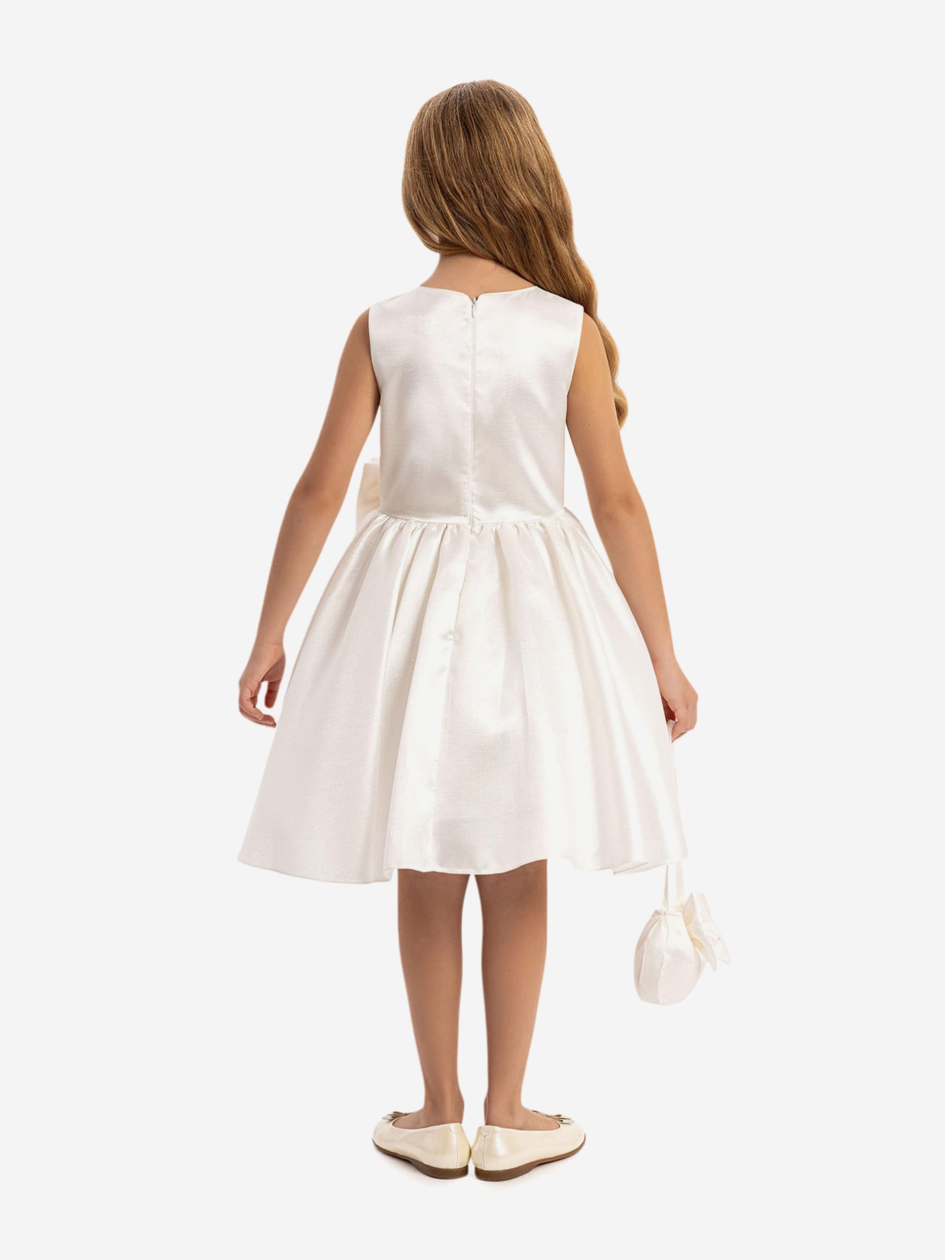 Back view: white satin dress with pleated skirt and waist bow, with mini bag