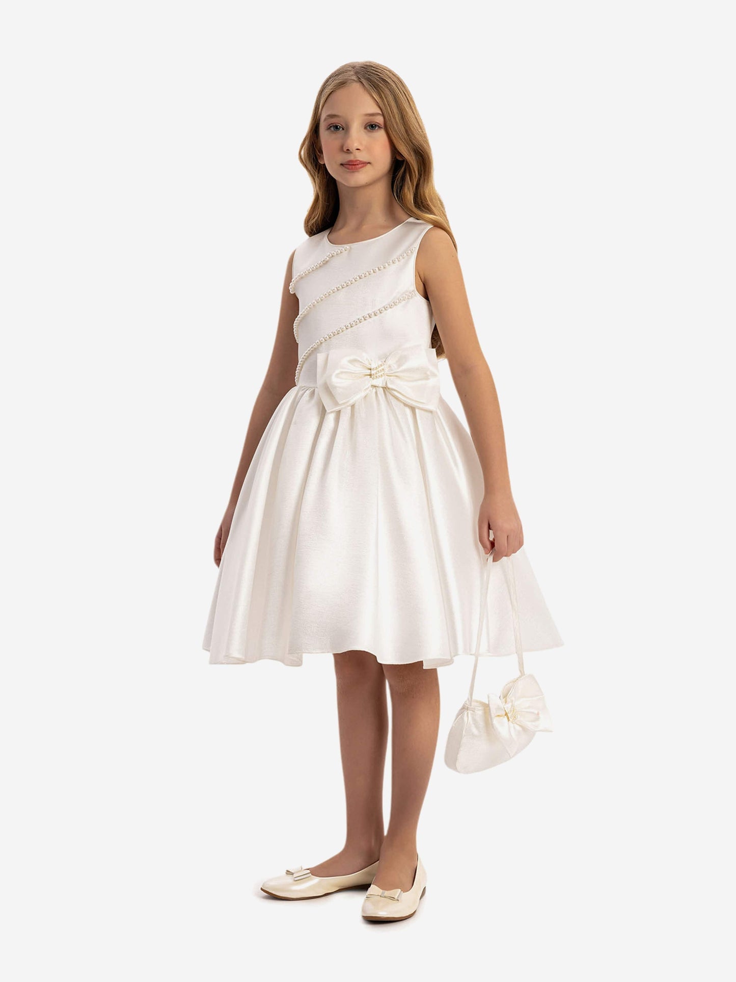 White satin dress with diagonal pearl trim and waist bow, paired with mini handbag