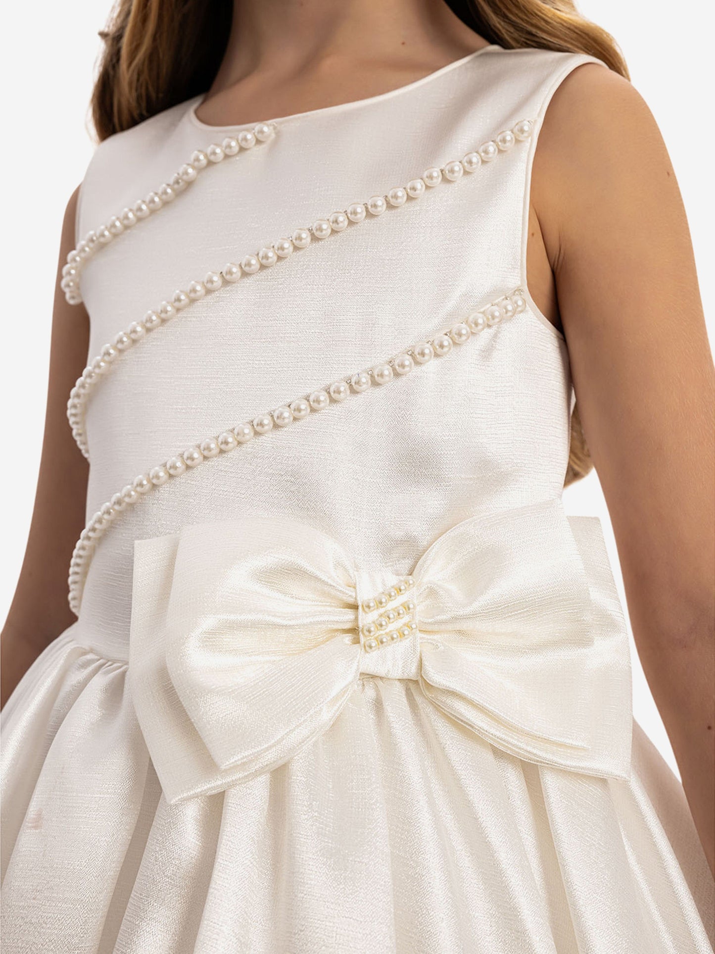 White satin bodice with pearl trim across straps and large bow at waist