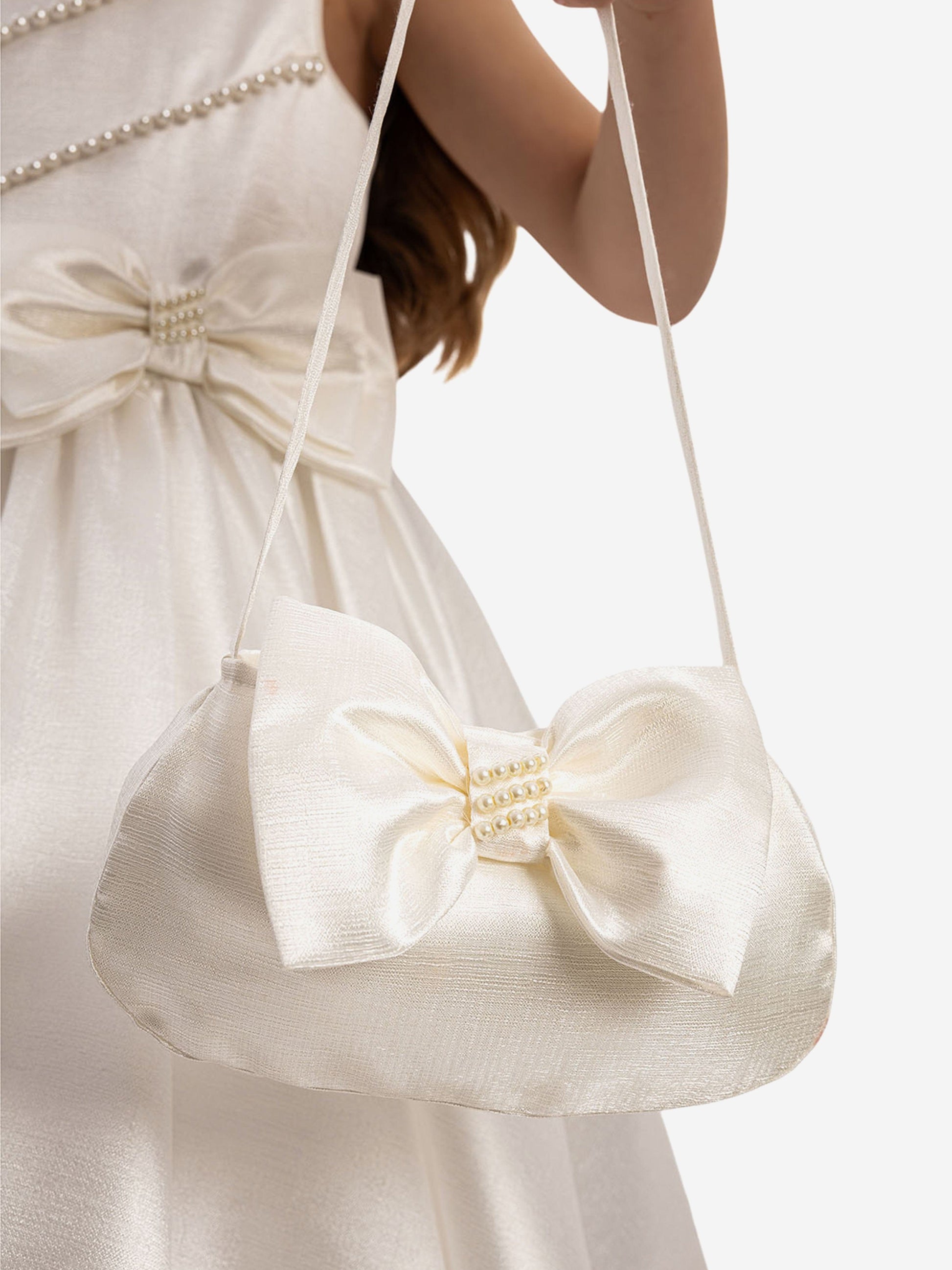 Matching white satin mini handbag with bow detail and pearl clasp