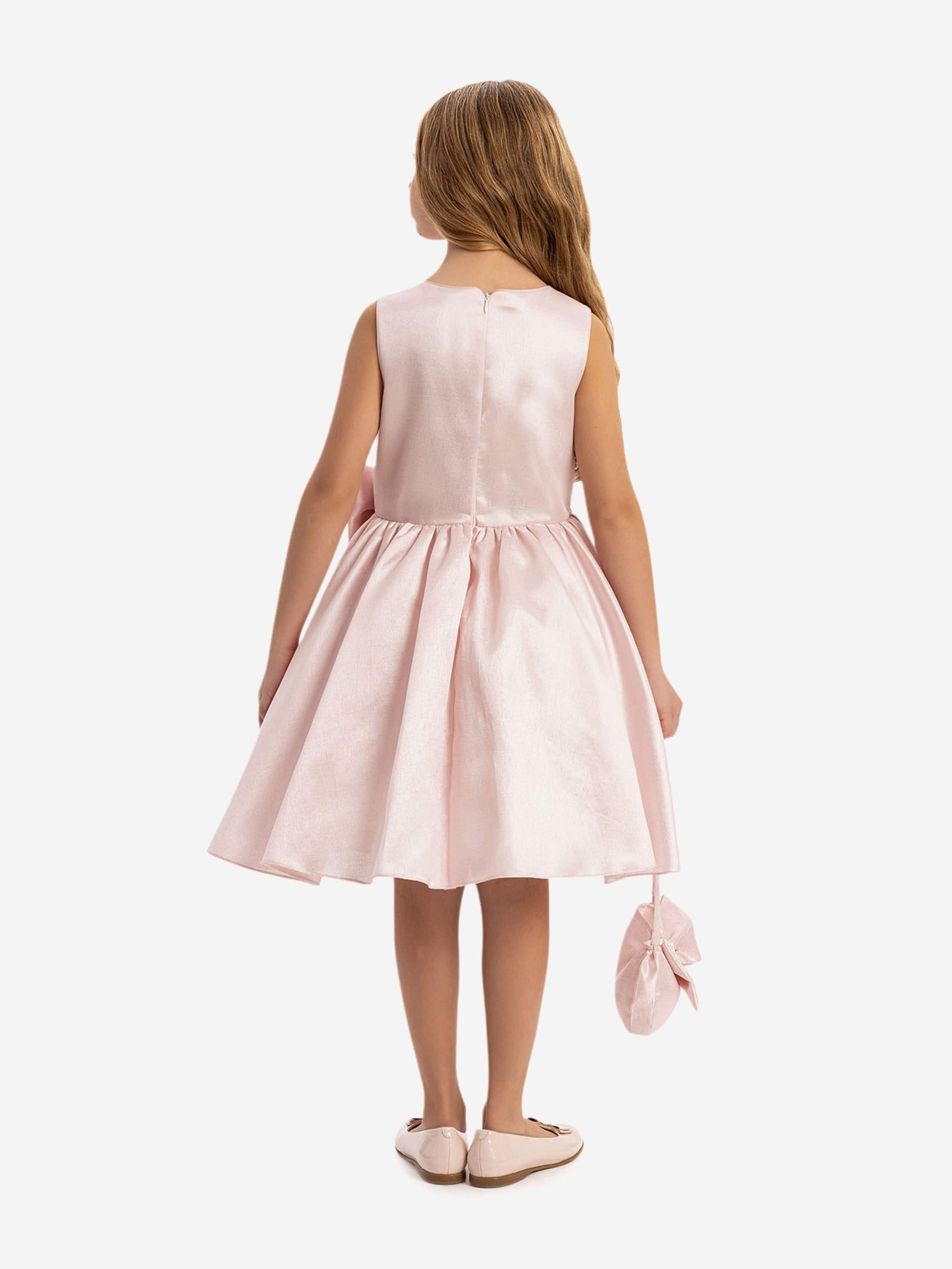 Girls pink satin dress from back view with bow waist and matching mini bag