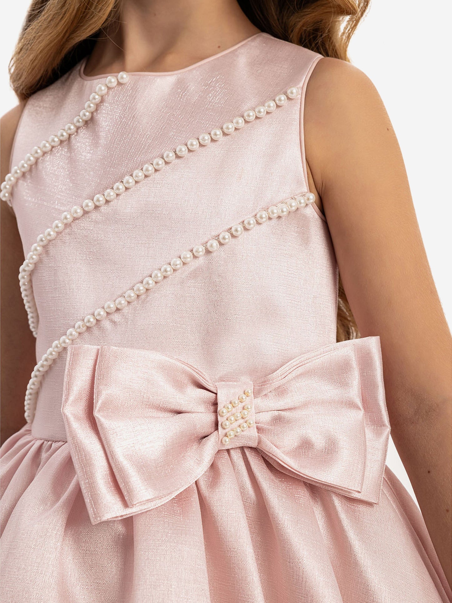 Close-up of pink satin dress bodice with pearl trim and bow detail