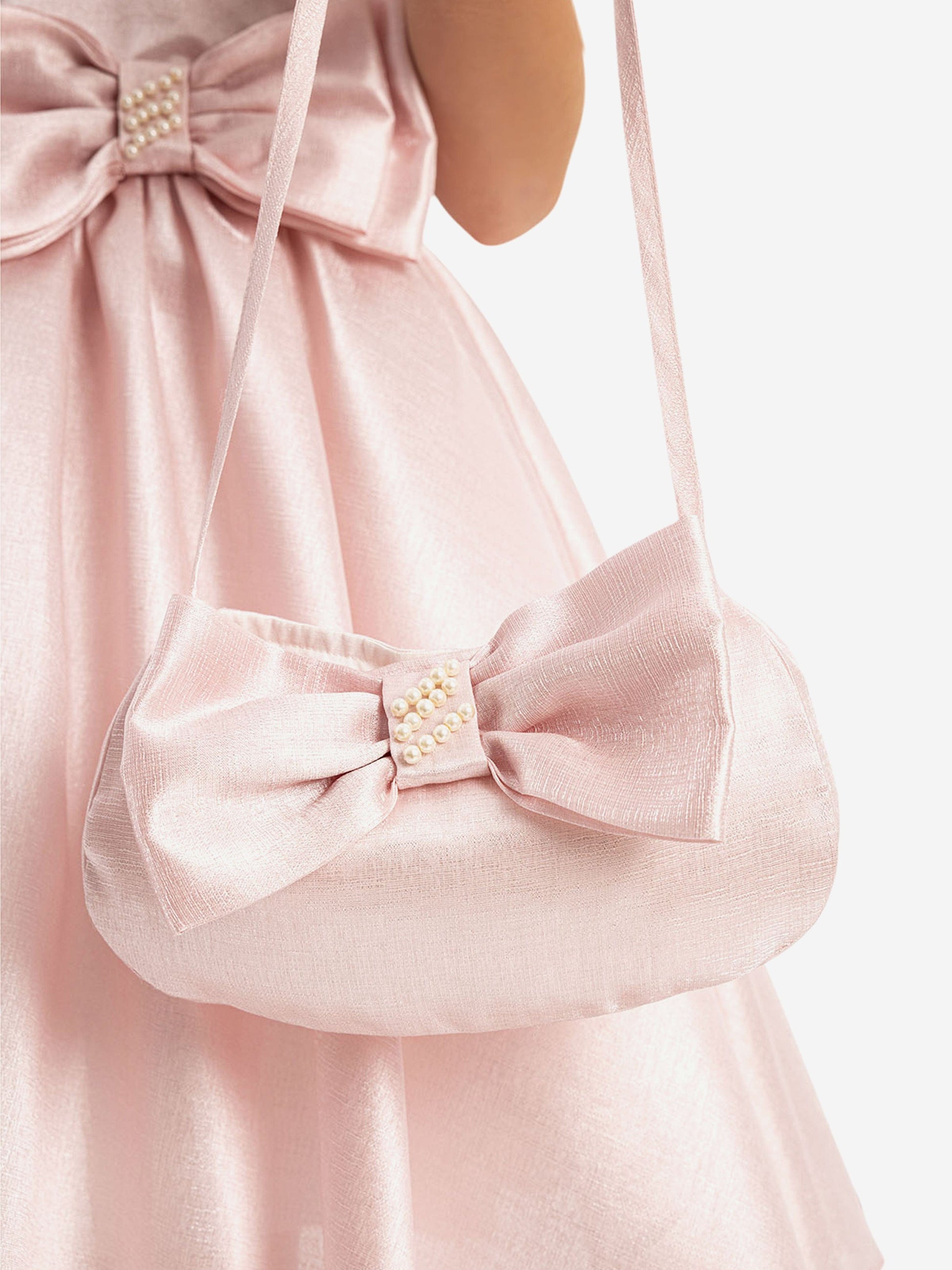 Matching pink mini bag with bow and pearl button detail, worn with dress