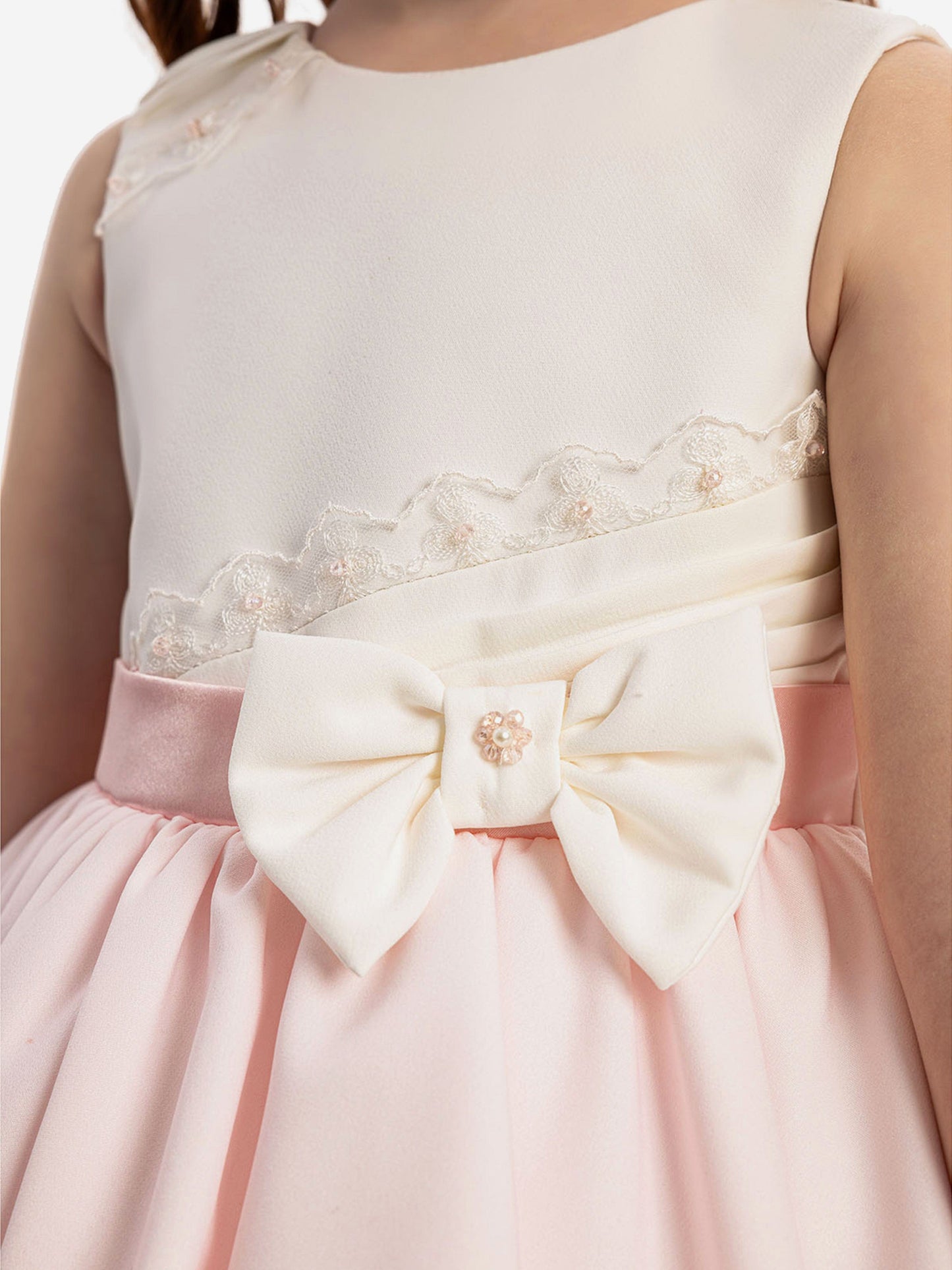 White lace bodice and satin waist bow on pale pink dress