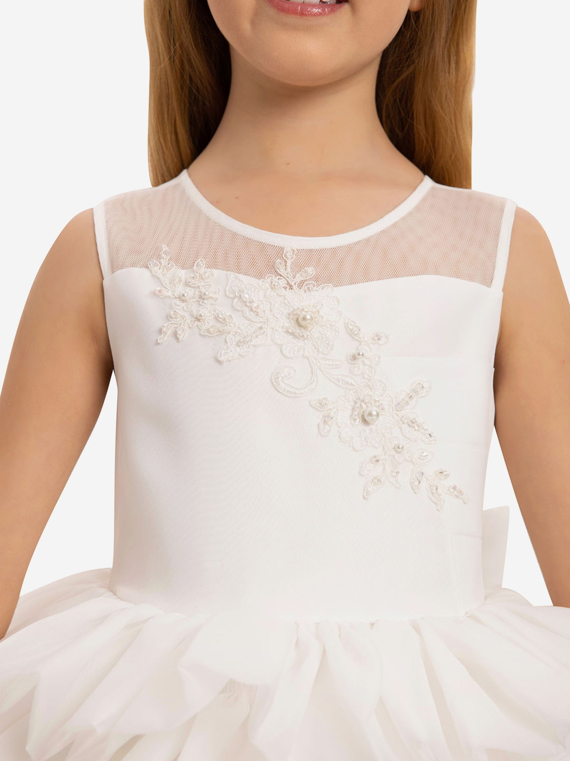 Close-up: white dress bodice with lace floral appliqué on mesh yoke and round neckline